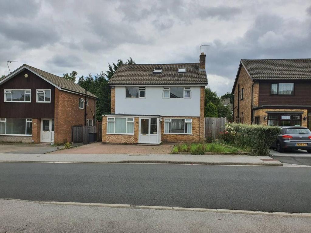 a white house on the side of a street at Detached 4-Bed House in Leeds in Leeds