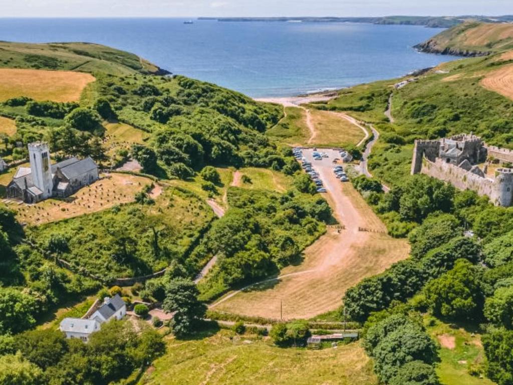 an aerial view of a castle on a hill next to the ocean at Shute Cottage in Manorbier