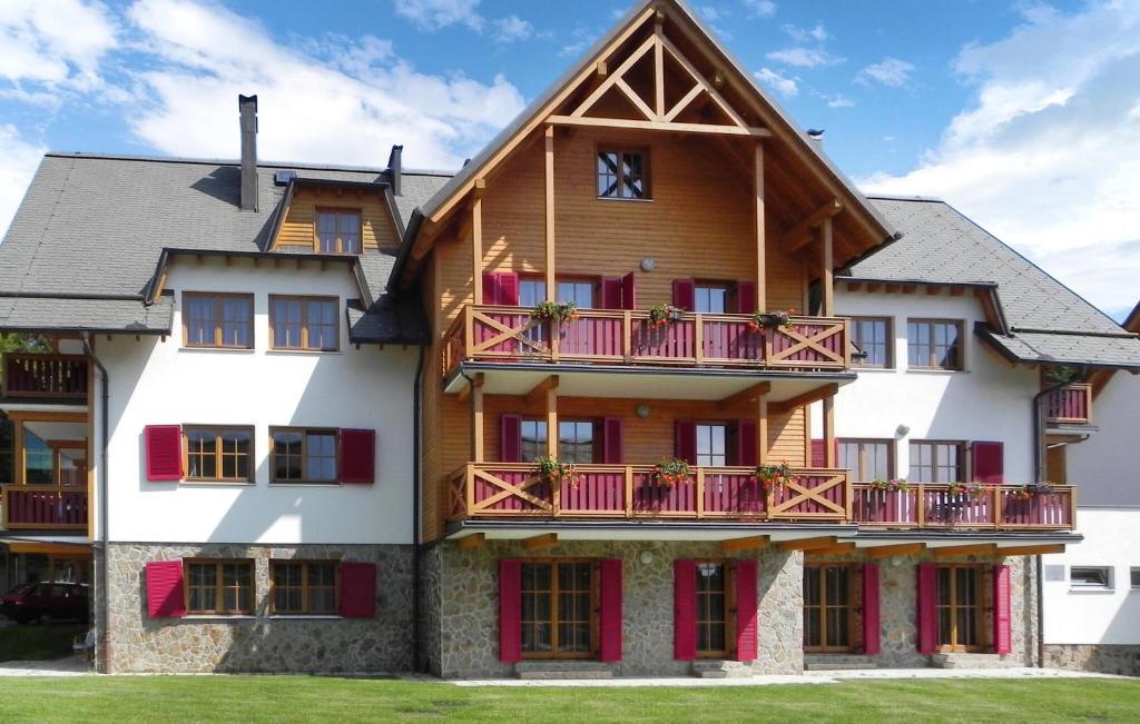 a large wooden house with red balconies at Lovely Apartment In Pohorje With Indoor Swimming Pool in Hočko Pohorje