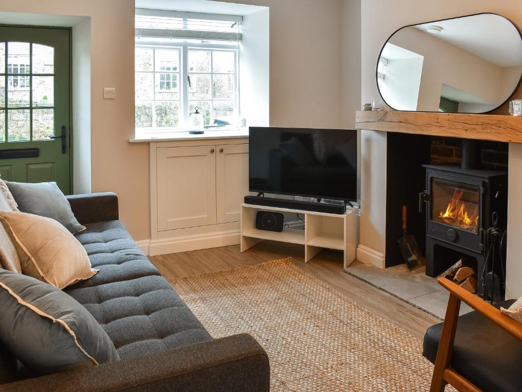 a living room with a couch and a fireplace at Bramble Cottage in Bramham