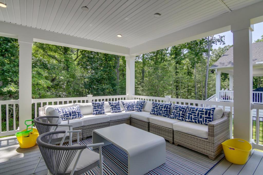 a screened in porch with a couch and chairs at Luxe Rehoboth Beach House with Community Pool and Gym! in Rehoboth Beach