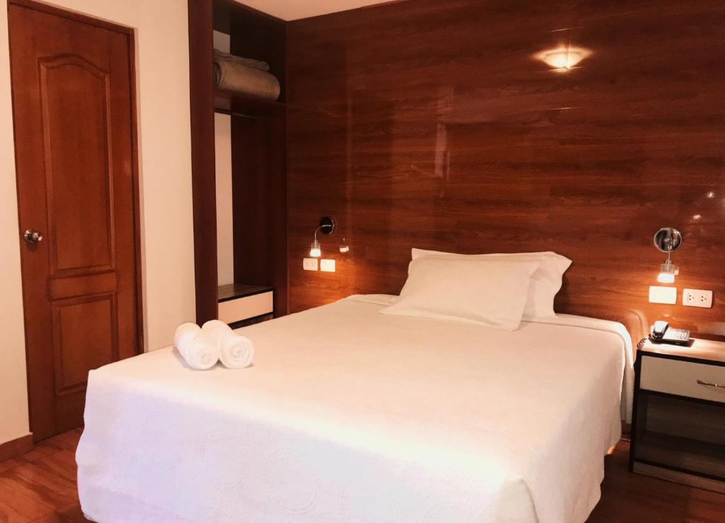 een slaapkamer met een wit bed en 2 handdoeken bij Estela de Oro Hotel Boutique in Arequipa