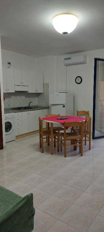 una cucina con tavolo rosso e sedie in legno di Appartamento Gianna ad Alghero