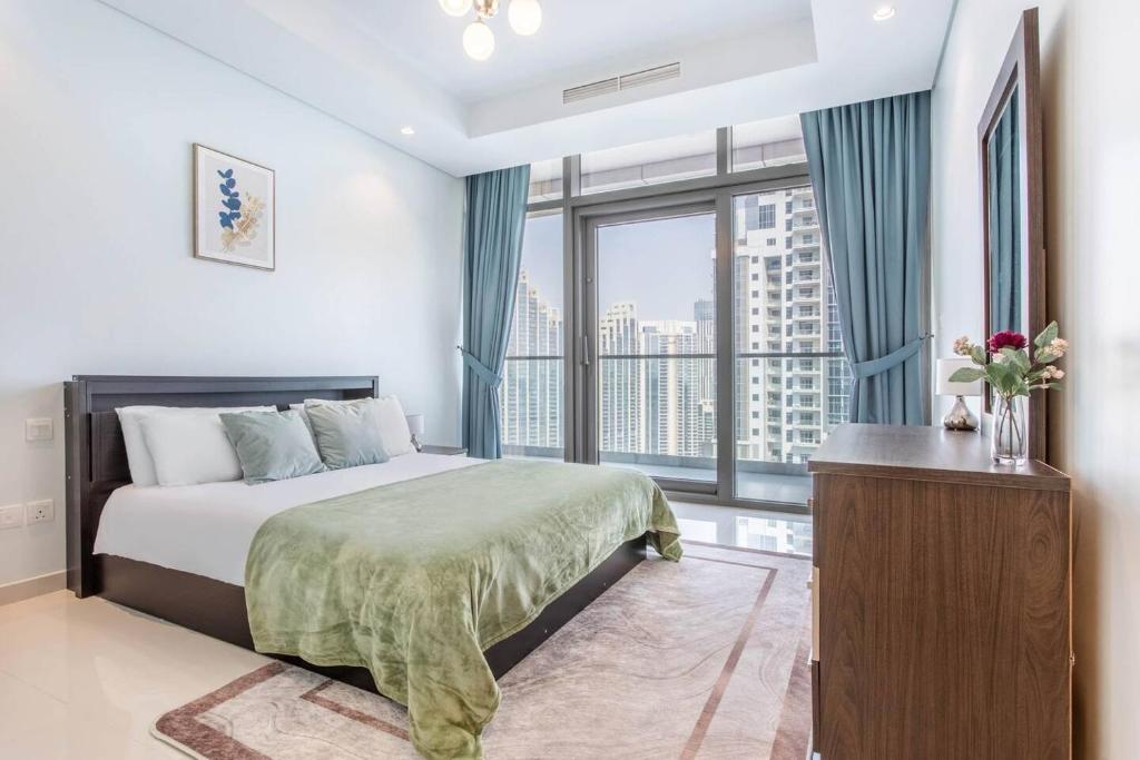 een slaapkamer met een bed en een groot raam bij Stunning 2br With Burj Views Infinity Pool in Dubai