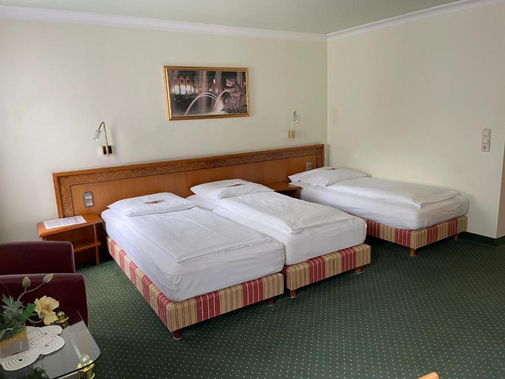 ein Hotelzimmer mit 2 Betten und einem Stuhl in der Unterkunft Hotel Ochsen in Stuttgart