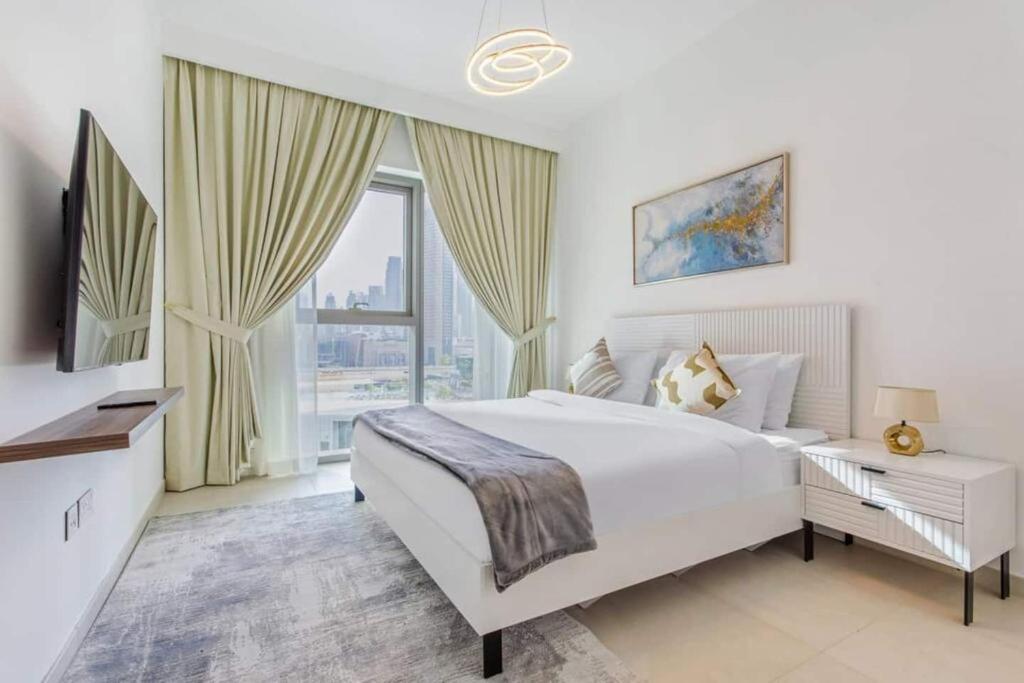um quarto branco com uma cama grande e uma janela em 3br Facing Dubai Mall 5 Min Walk To Burj Khalifa em Dubai