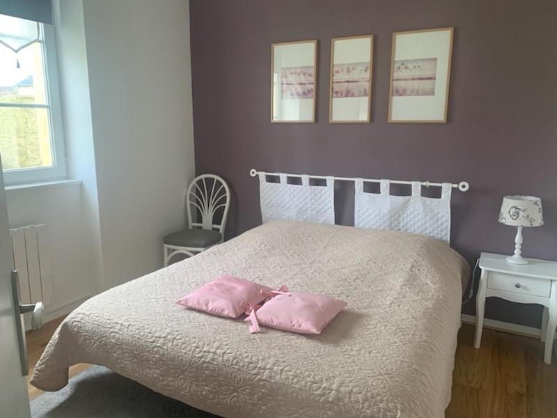 a bedroom with a bed with two pink pillows on it at Jadis, l'école de Maisy, port et plage au bout de l'avenue in Grandcamp-Maisy