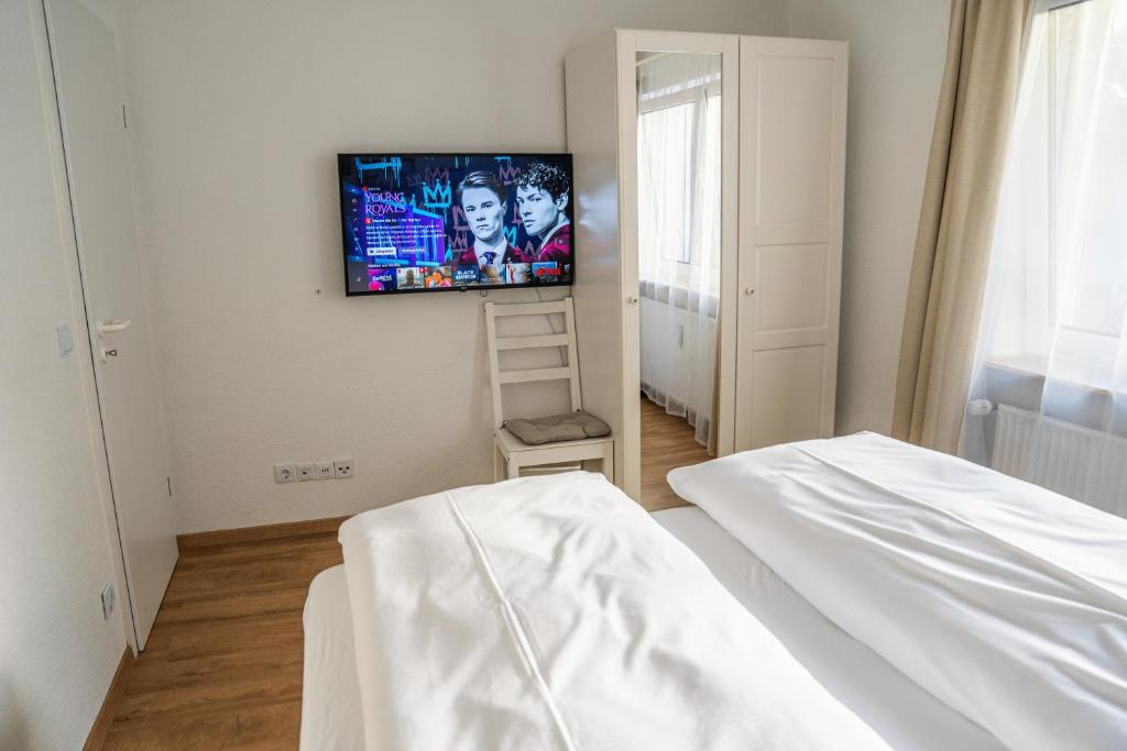 1 dormitorio con 1 cama y TV en la pared en City Apartments Gerlingen en Gerlingen