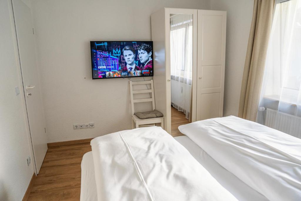 a bedroom with a bed and a tv on the wall at City Apartments Gerlingen in Gerlingen