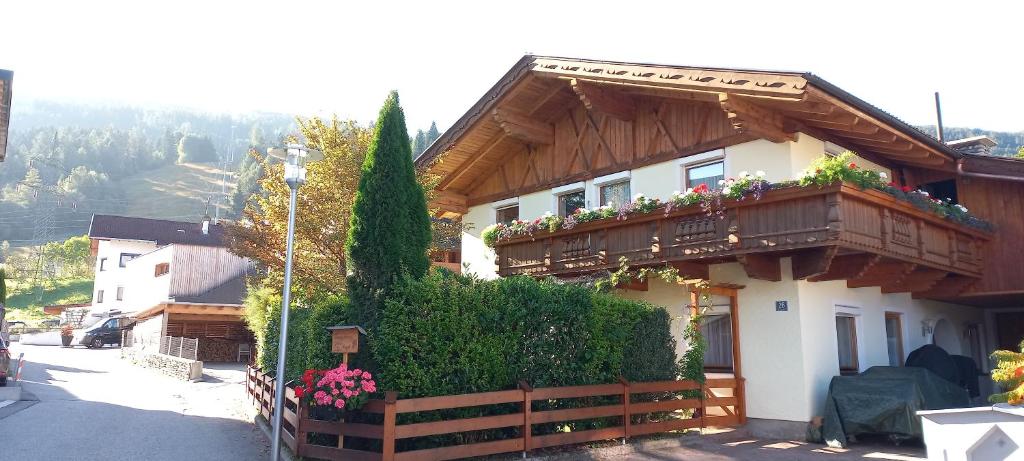 una casa con un balcón con flores. en Ferienwohnung Götzner Auszeit en Innsbruck