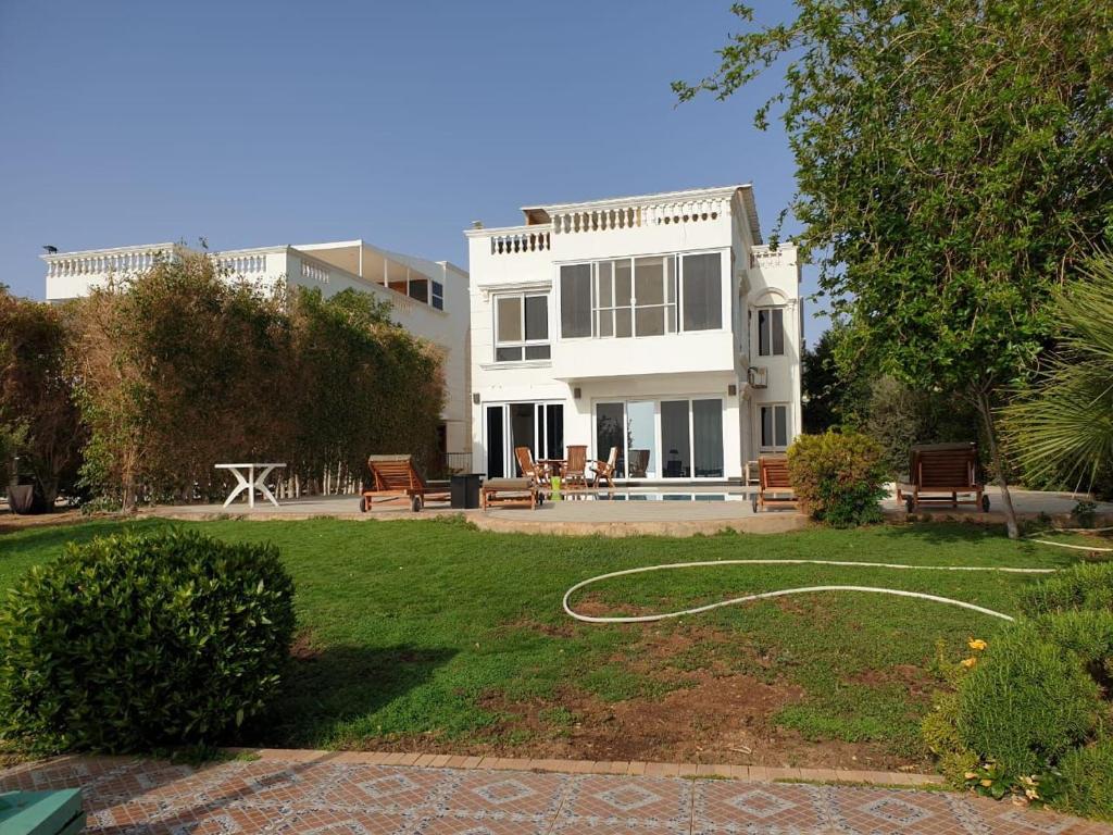 una gran casa blanca con una manguera en un patio en Vacation villa in Sharm El Sheikh on the beach en Sharm El Sheikh