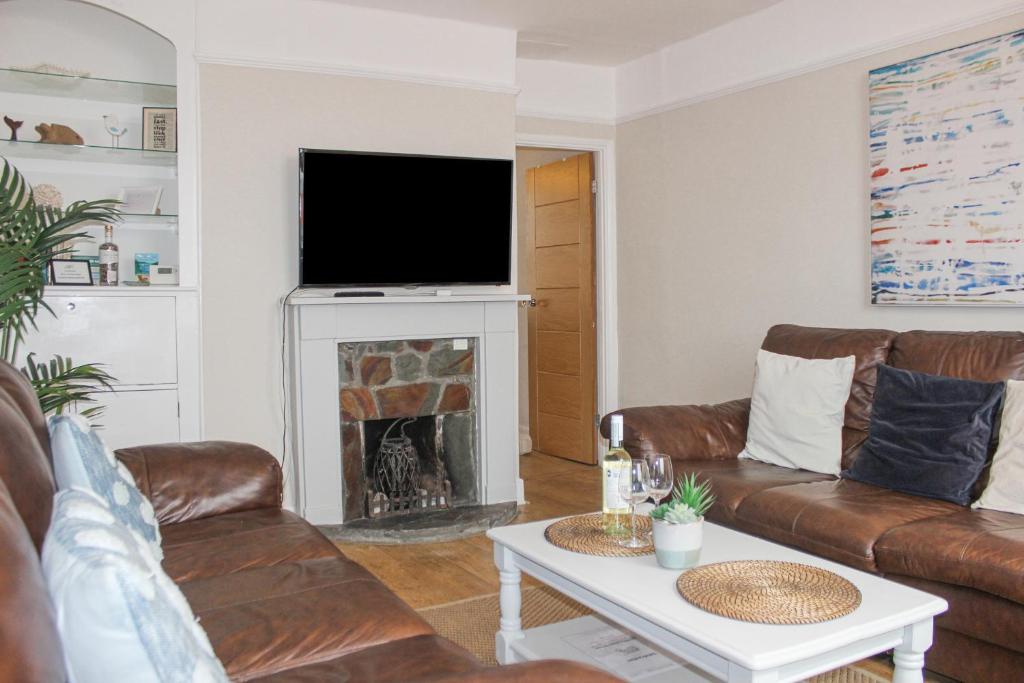 a living room with a couch and a fireplace at Sandcastles 15A Fore Street in Salcombe