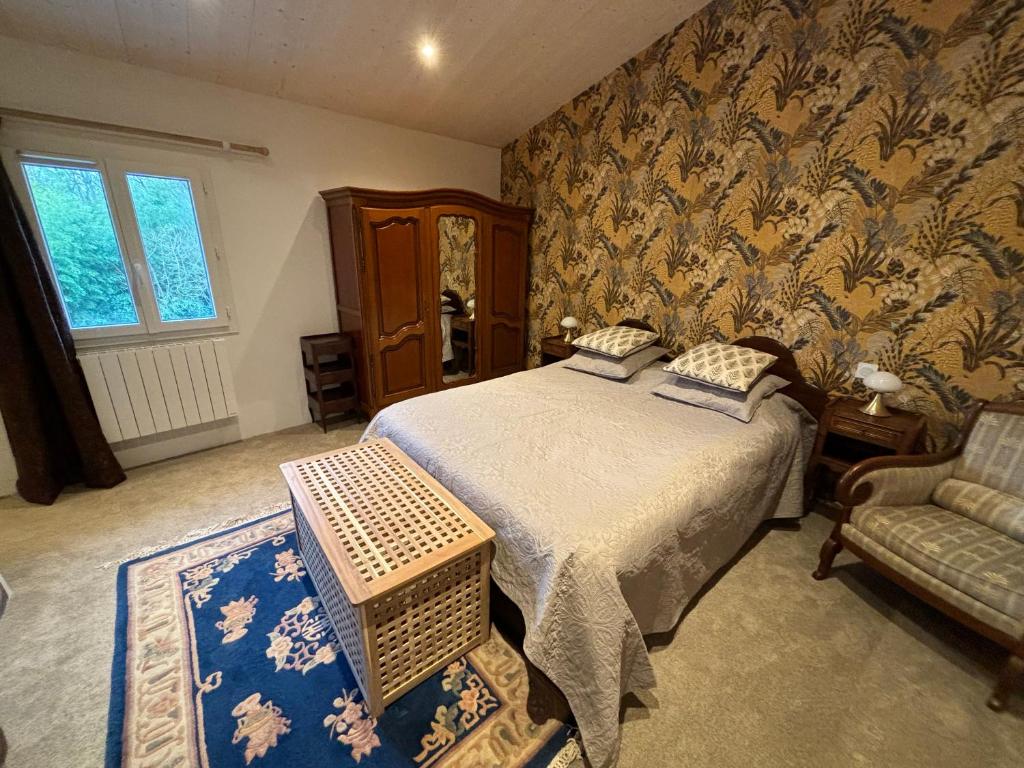 ein Schlafzimmer mit einem Bett und einem Stuhl in der Unterkunft L'auberge'Inn in Coulon