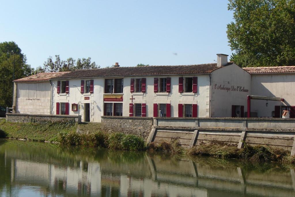 un antiguo edificio junto a un cuerpo de agua en L'auberge'Inn, en Coulon