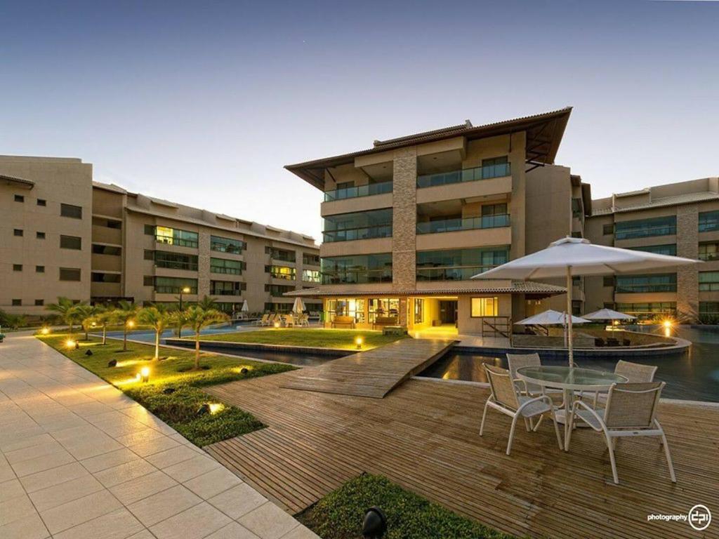 a courtyard with a table and chairs and a building at EKOARA BEIRA MAR 127 in Porto De Galinhas