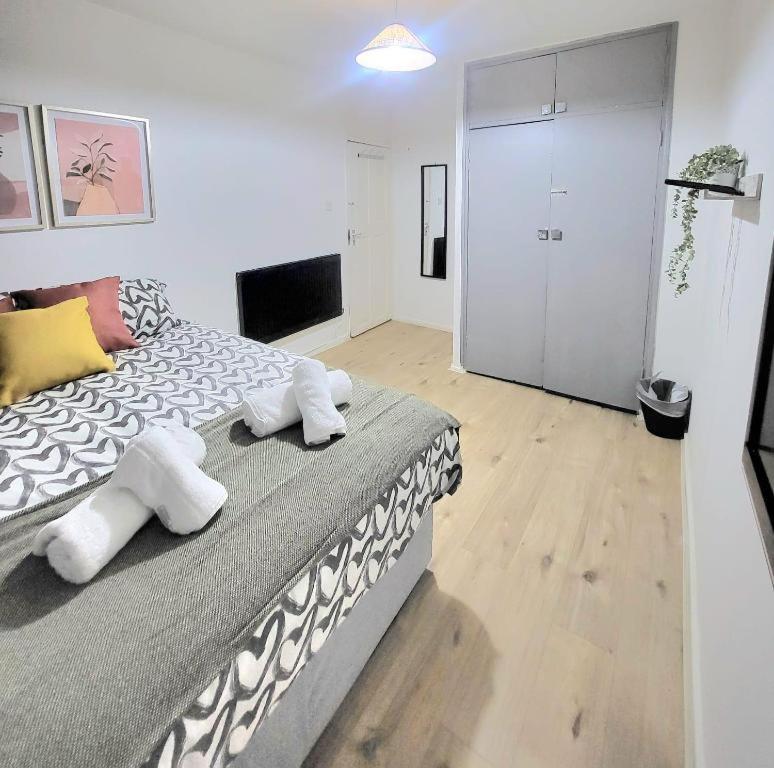 a bedroom with a large bed with towels on it at Three Bed Flat In Mile End in London