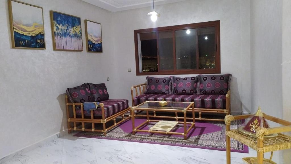 a living room with two purple couches and a window at appartement équipé in Tangier