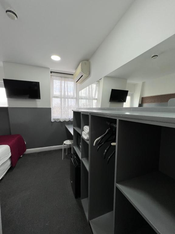 Habitación con cama y escritorio con armarios. en Plaza London Hotel, en Londres