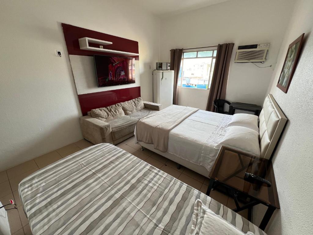 um pequeno quarto com 2 camas e um frigorífico em Apartamento Centro Manaus 721 em Manaus