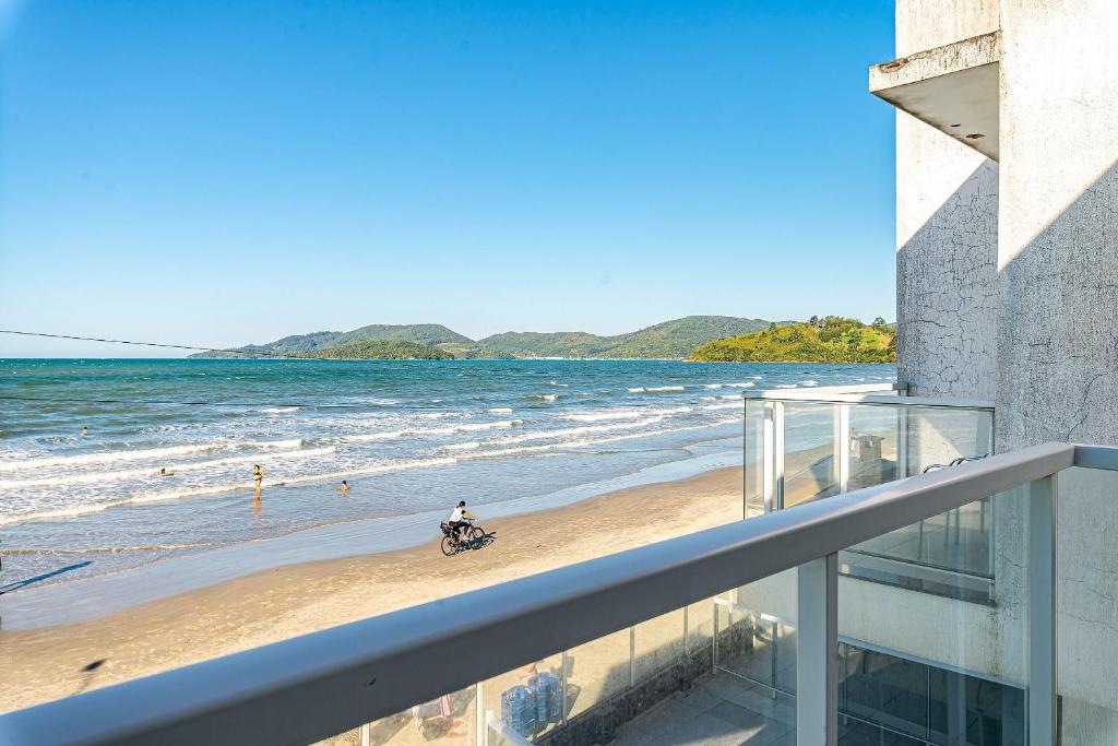 una persona in bicicletta sulla spiaggia di Duplex pé na areia com vista deslumbrante RAT001 a Porto Belo