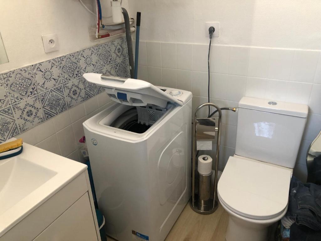 een badkamer met een wasmachine en een toilet bij Joli appartement avec jardin dans résidence avec piscines in Agay - Saint Raphael