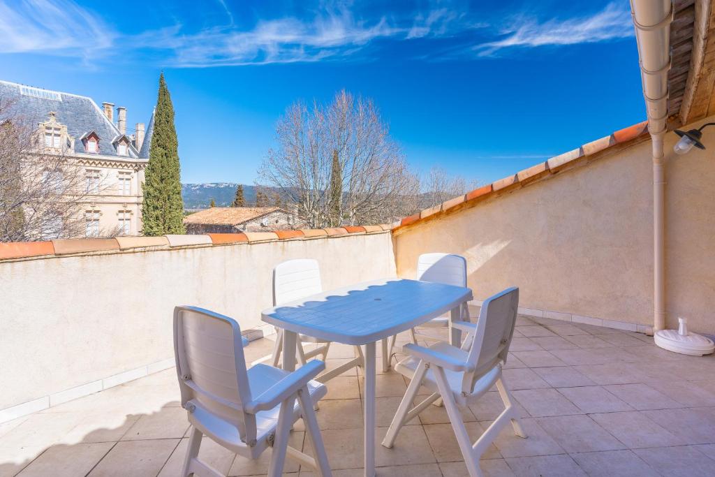 una mesa azul y 4 sillas en el balcón en Au village f3 climatisé terrasse en Charleval