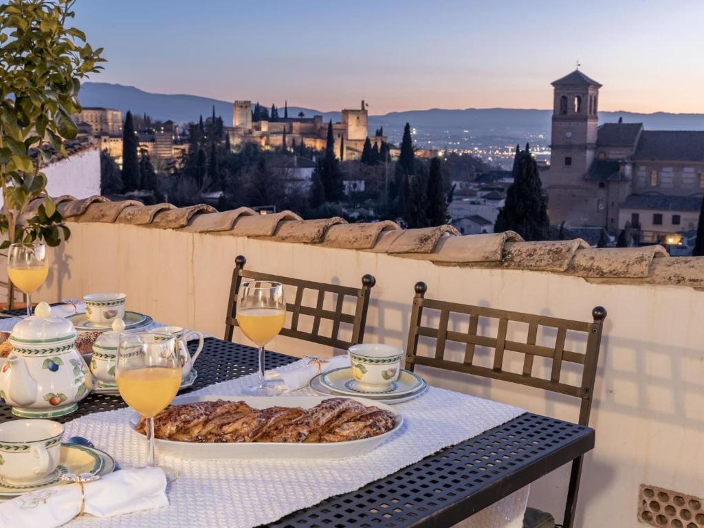 een tafel met een bord eten en een glas wijn bij Alhambra Luxury Albaicin in Granada