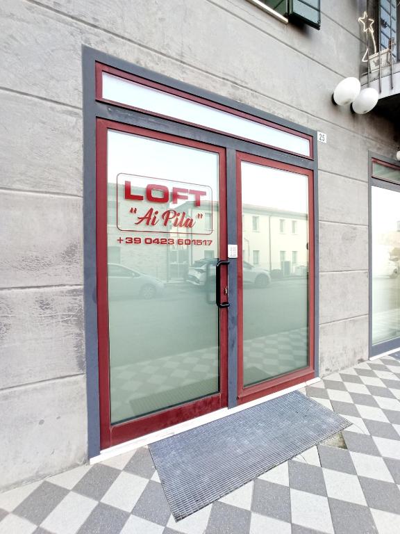 un frente de tienda con un cartel en una ventana en IL LOFT AI PILA, en Montebelluna