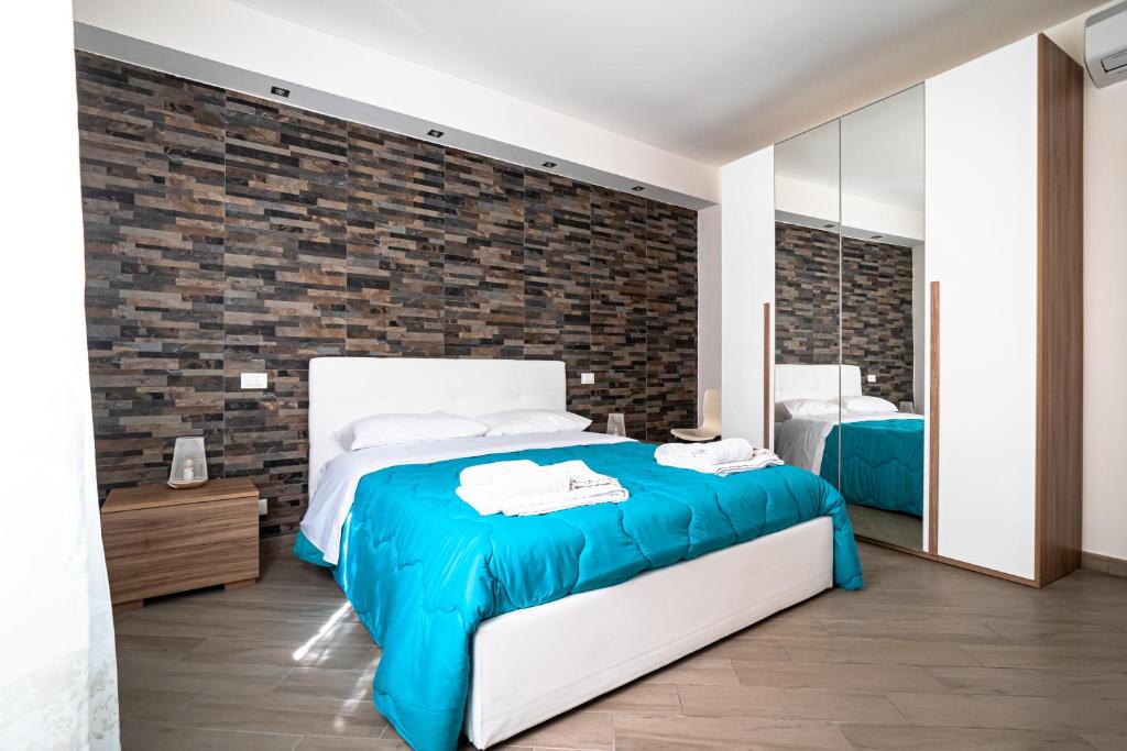 a bedroom with a bed and a brick wall at U ventu che tira casa centro storico vicino porto wi fi in Trapani