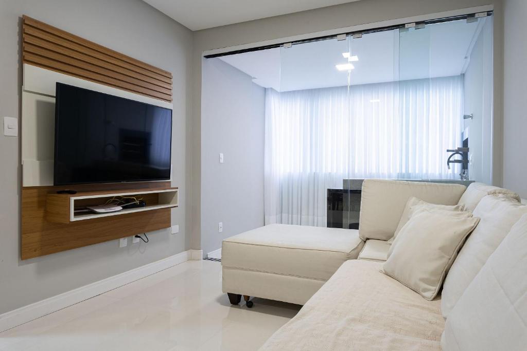 Il comprend un salon doté d'un canapé et d'une télévision à écran plat. dans l'établissement Apto aconchegante a 450m do mar EAN503, à Balneário Camboriú