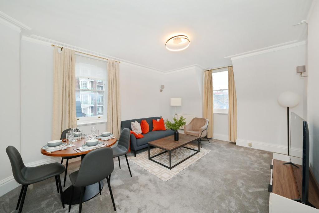 ein Wohnzimmer mit einem Sofa und einem Tisch in der Unterkunft London Choice Apartments - Baker Street- Regent's Park in London