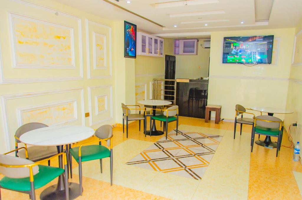 una habitación con mesas y sillas y una cocina en E45 Hotels and Suites en Owerri