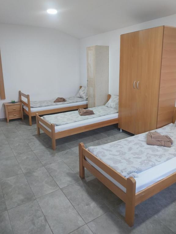 a group of three beds in a room at LIBERO APARTMANI in Surčin
