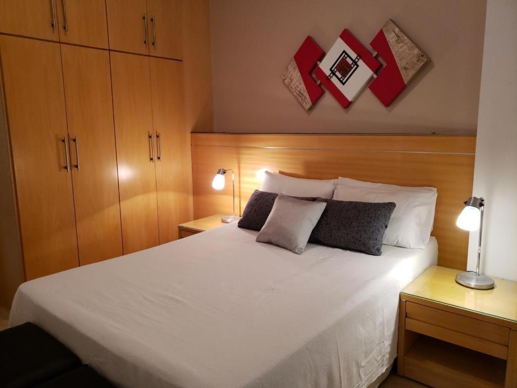 1 dormitorio con 1 cama blanca grande y 2 lámparas en South Beach Copacabana, en Río de Janeiro
