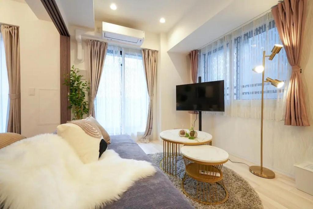 a living room with a couch and a tv at Mondomio Sapporo Minamisanjo Dori - Vacation STAY 16334 in Sapporo