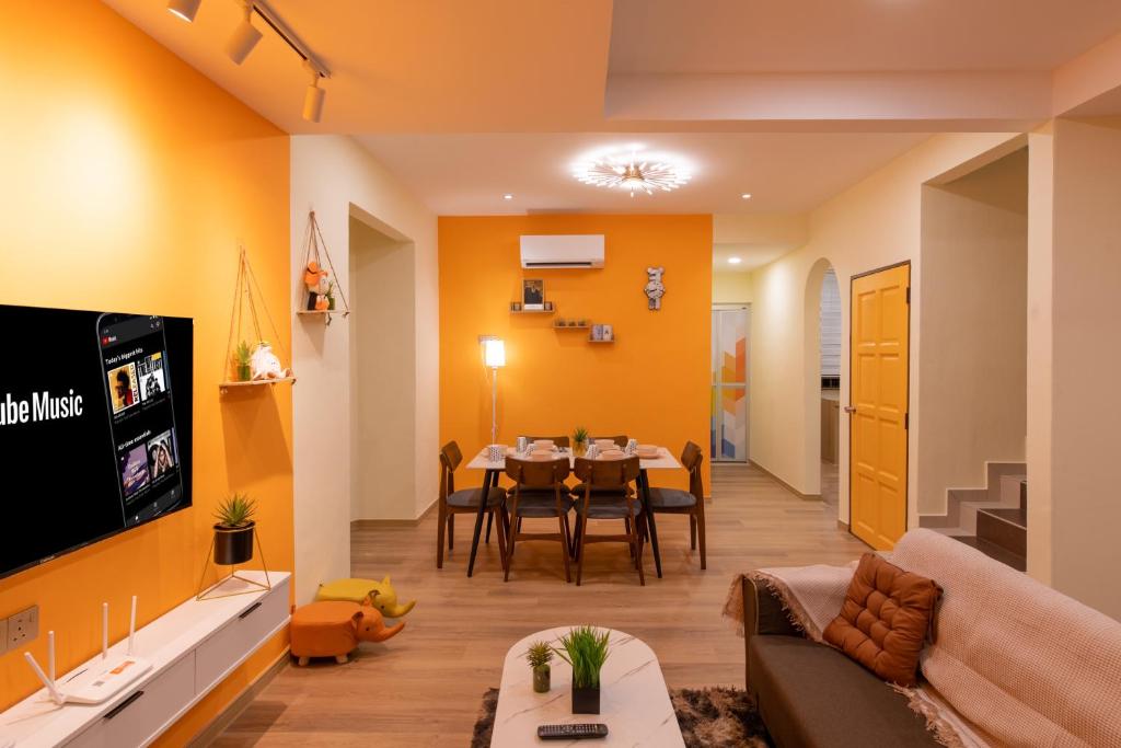 un soggiorno con divano e sala da pranzo di Orange Tatami Funny House at Bukit Beruang Malacca a Malacca