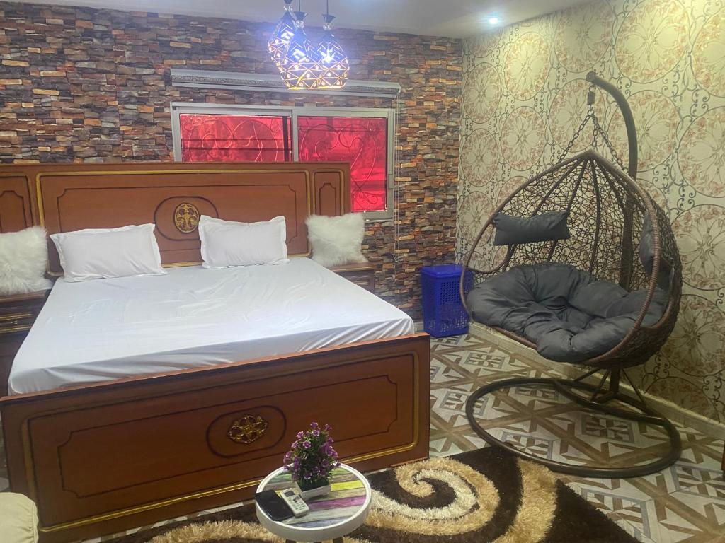 a bedroom with a bed and a swing chair at La fierté in Ziguinchor