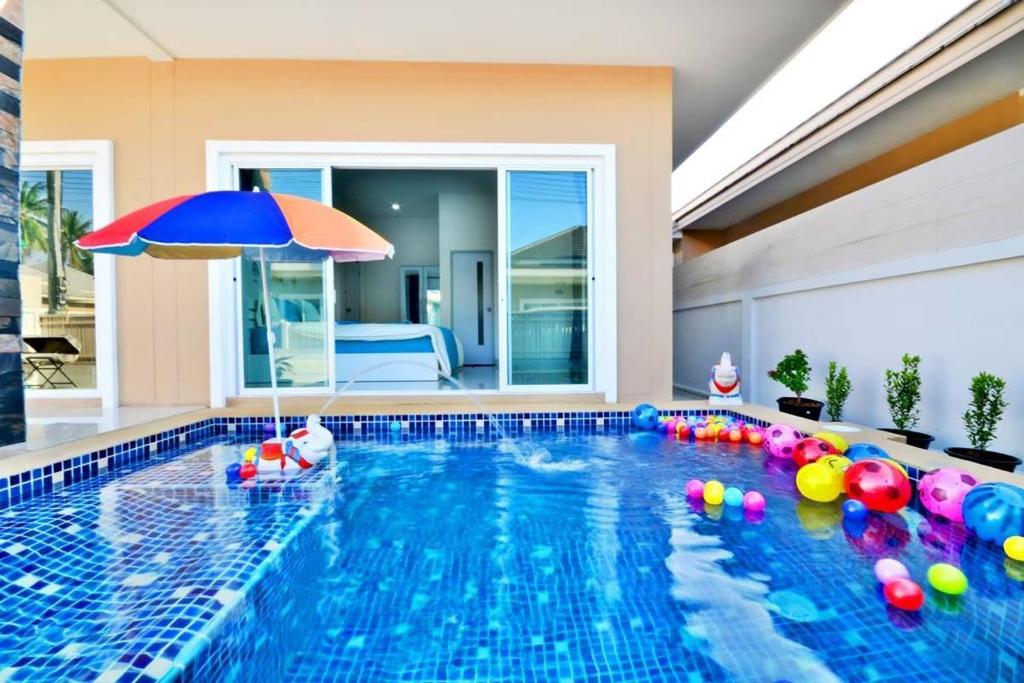 a swimming pool with an umbrella and balls in it at The Guestvilla644 in Hua Hin