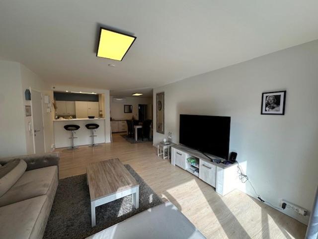 a living room with a couch and a flat screen tv at Appartement Anthony in Blankenberge