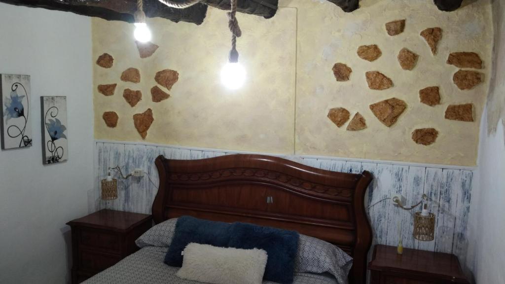 Casa de pueblo García Marquez في Geldo: غرفة نوم بسرير وجدار عليه قلوب