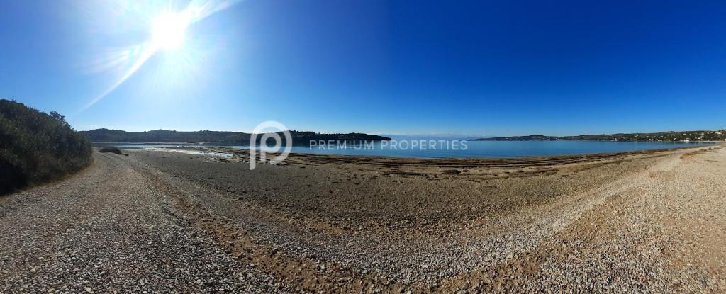 a dirt road next to a body of water at Villa Tranquility - Walk to the Beach with Infinity Pool in Porto Heli