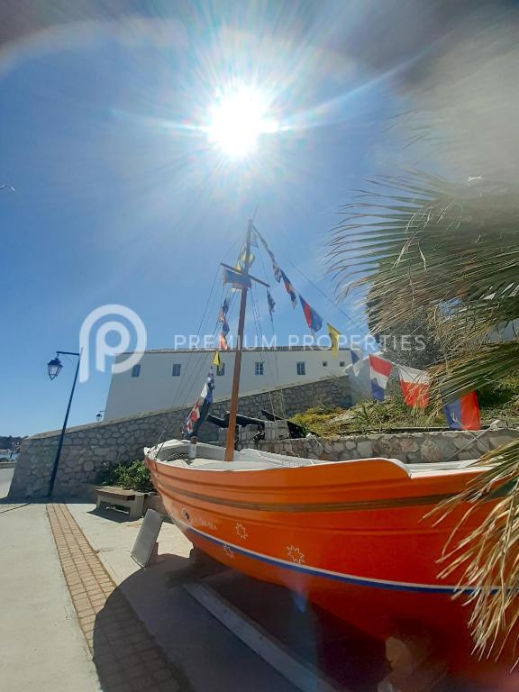 an orange boat sitting on a sidewalk next to a building at Villa Tranquility - Walk to the Beach with Infinity Pool in Porto Heli