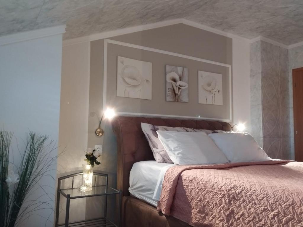 een slaapkamer met een bed met twee foto's aan de muur bij Apartments Rustika Toscana in Vodice