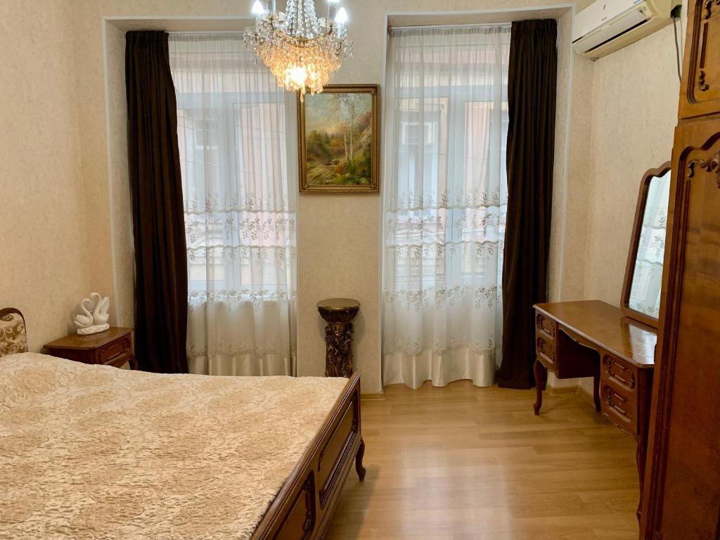 ein Schlafzimmer mit einem Bett, einer Kommode und zwei Fenstern in der Unterkunft Best Location Renovated Home in Tbilisi City