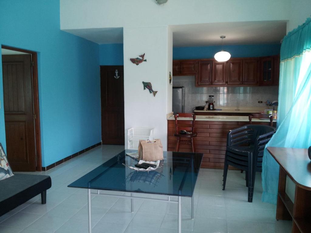 sala de estar con mesa de cristal frente a la cocina en Apartment Caribbean Relax, en Boca Chica