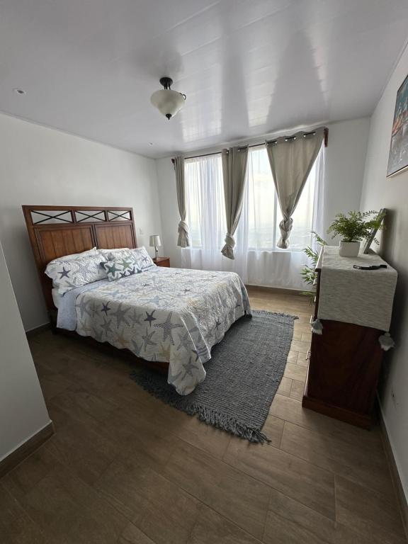 1 dormitorio con cama y ventana grande en Villa Celajes, en Barva