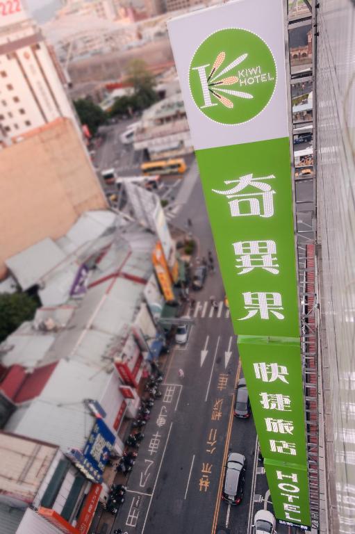 a green and white sign on the side of a building at KIWI-Taichung Station Branch 1 in Taichung