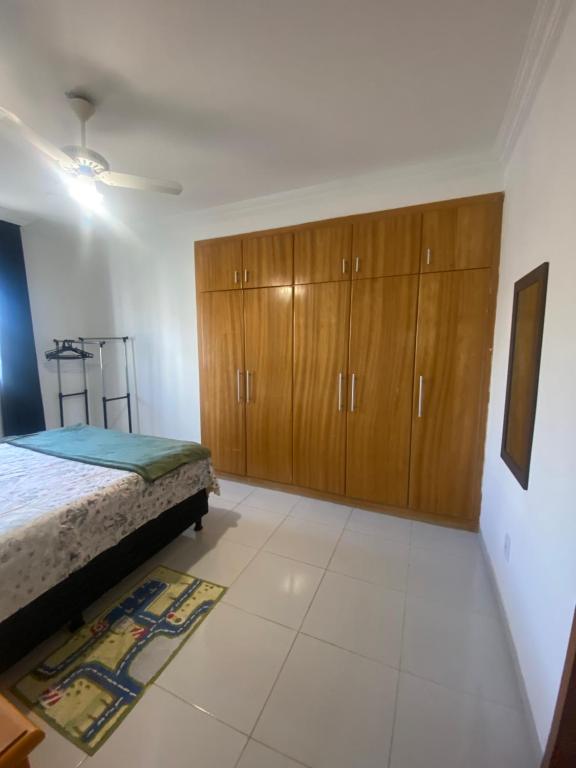 um quarto com uma cama e armários de madeira em Suite em Boa Viagem para mulheres e casal no Recife