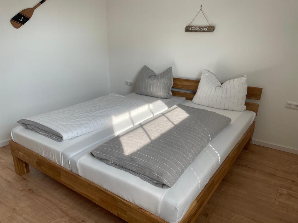 Bett mit weißer Bettwäsche und Kissen in einem Zimmer in der Unterkunft Ferienwohnung Durchholz in Steinhude