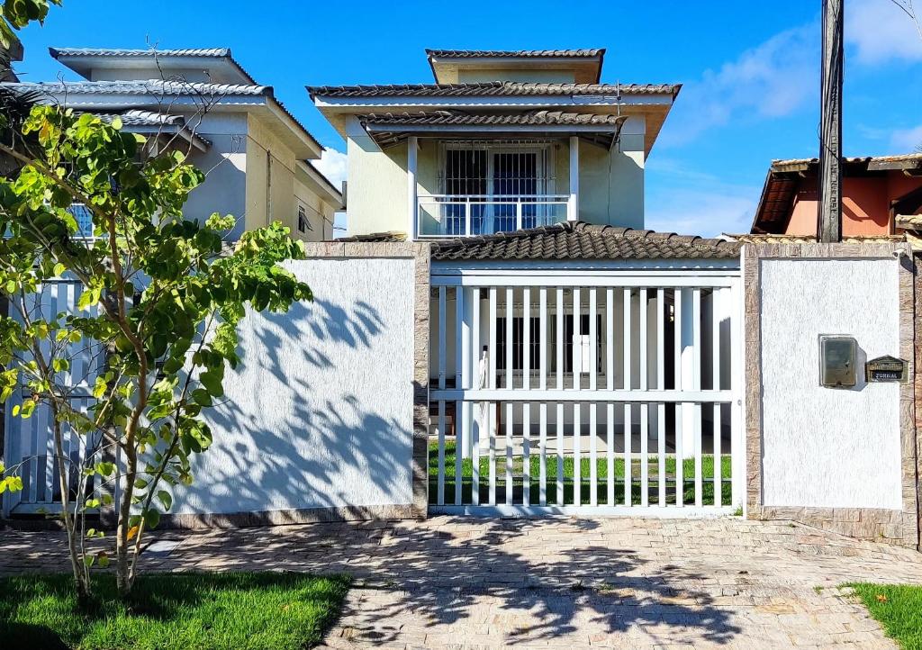 a villa with a gate in front of a house at Casa Piscina em Condomínio 5min Praia ITACOATIARA. in Niterói